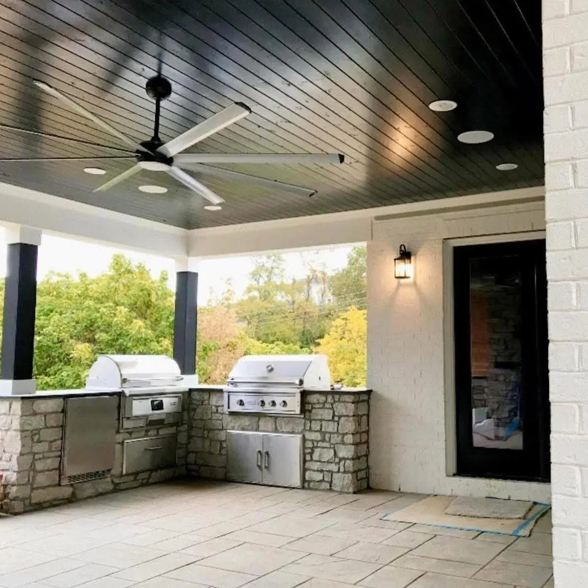 Custom outdoor kitchen with built-in grills under a covered patio
