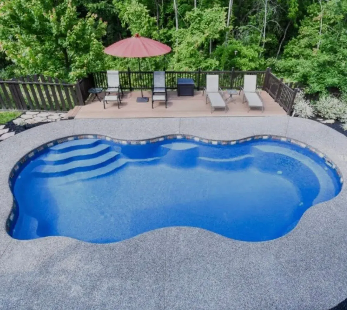 Aerial view of kidney-shaped pool with wood deck