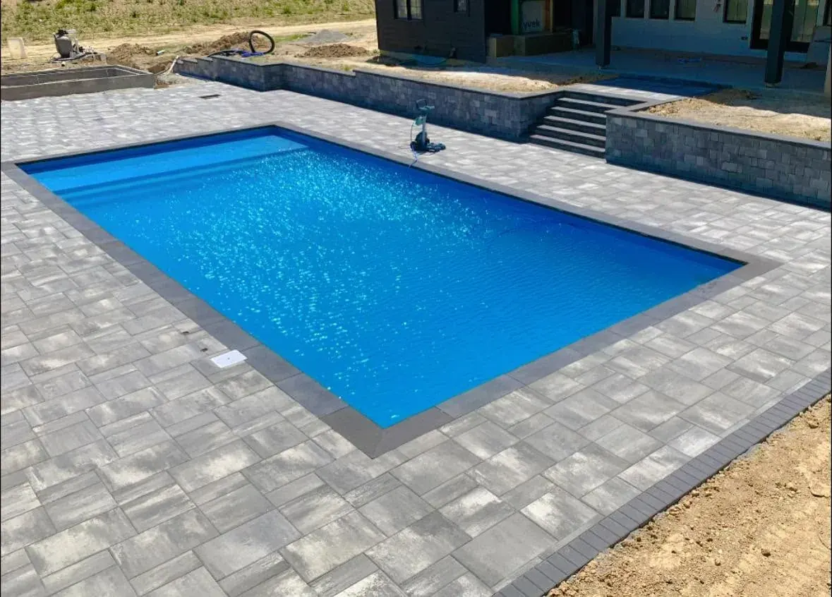 Landscaped pool patio with wood pergola and lounge seating