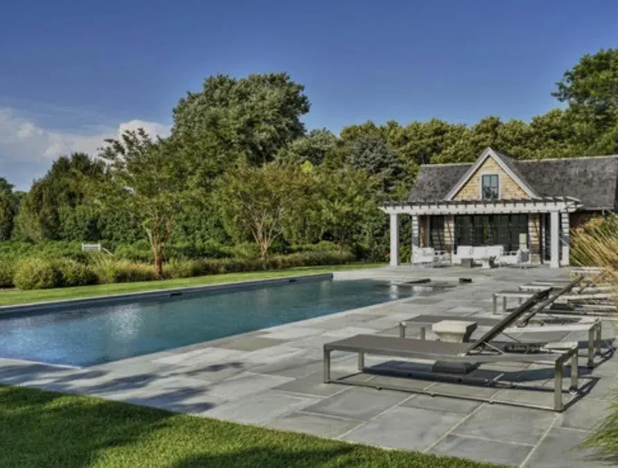 Rectangular pool with bluestone patio and shingle pool house