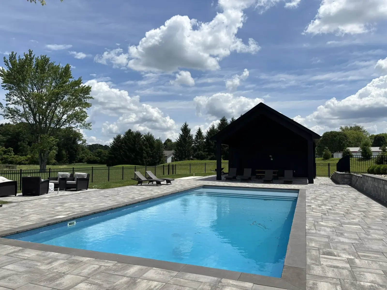Custom inground pool with paver patio and modern pool house built by Maui Pools in the Cincinnati, Ohio area
